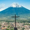 Scenic view of Guatemala volcano with cultural market and ancient ruins, ideal for travel and tourism packages
