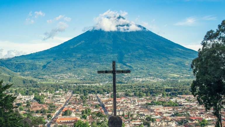 Scenic view of Guatemala volcano with cultural market and ancient ruins, ideal for travel and tourism packages