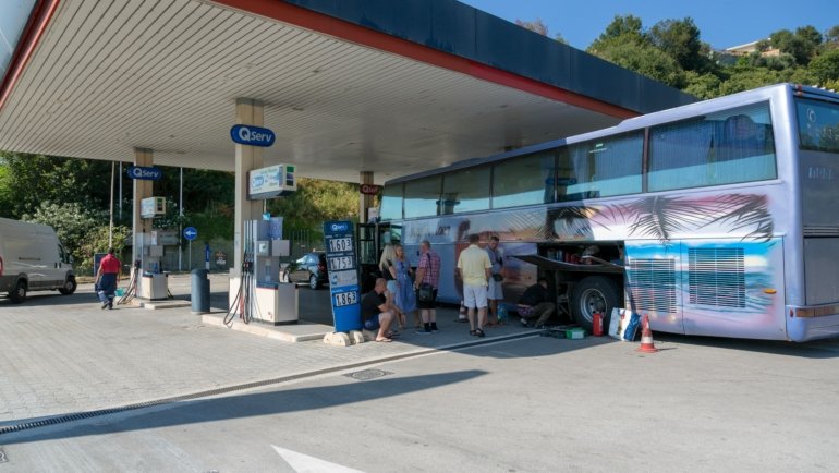 On The Run Travel Center with fuel pumps, fresh food store, and travelers stopping for a break on a busy highway