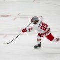 Hockey puck flying at high speed across smooth ice during a professional game