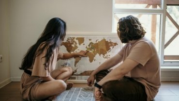 Couple planning their next trip together using a travel map, symbolizing shared adventure and travel planning