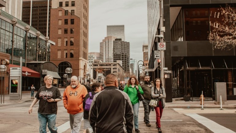 Vibrant downtown city street with pedestrians exploring shops, landmarks, and cultural attractions
