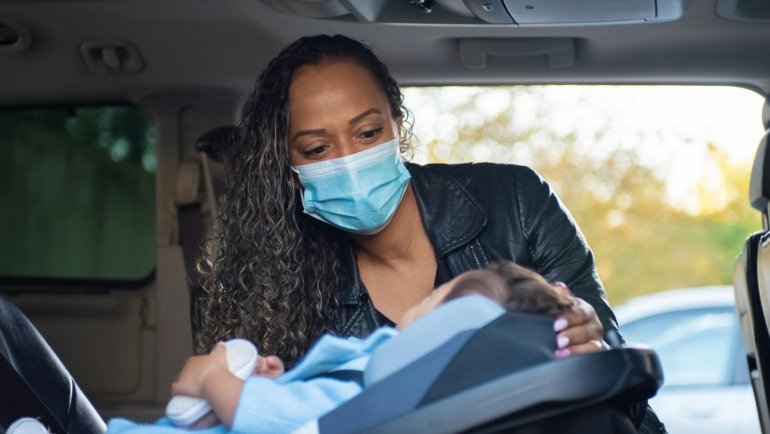 Child safely seated in a Maxi Cosi travel car seat inside a family car during a trip