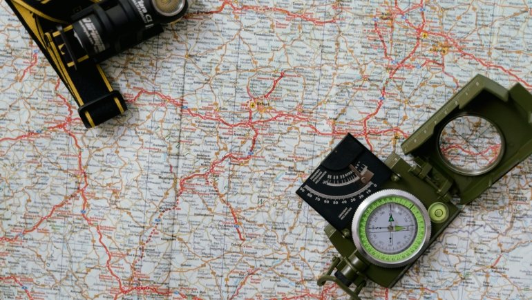 Traveler using Colorado travel guide book and map with Rocky Mountains in the background