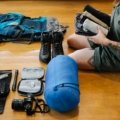 Traveler packing durable backpack and travel accessories with tech gadgets for world exploration