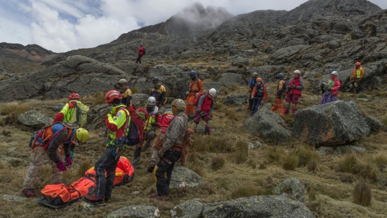 Mountain rescue team assisting injured skier during winter sports trip