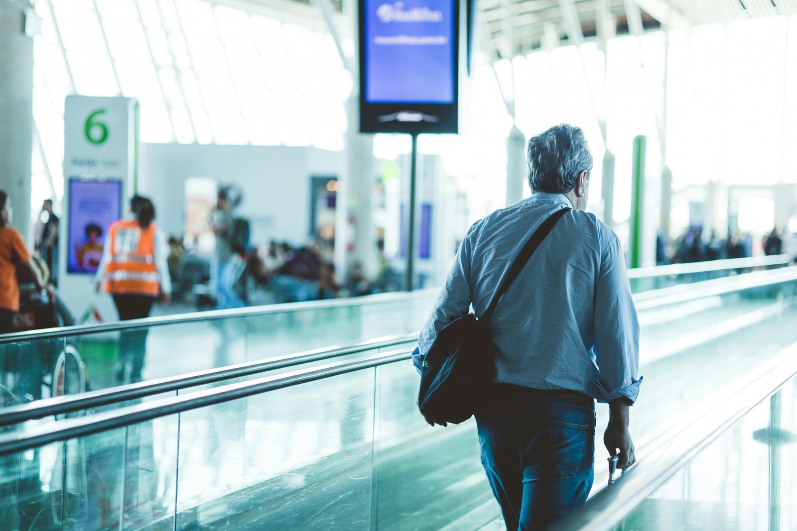 Man wearing wrinkle-resistant travel sport coat with pockets at airport, demonstrating style and comfort for business travel