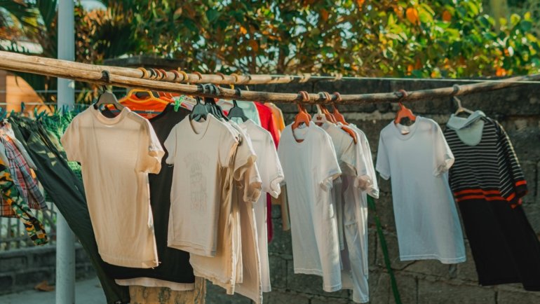 Portable travel clothesline hanging between trees with clothes drying outdoors during a camping trip