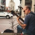 Traveling musician performing outdoors with guitar, embracing freedom and cultural exploration