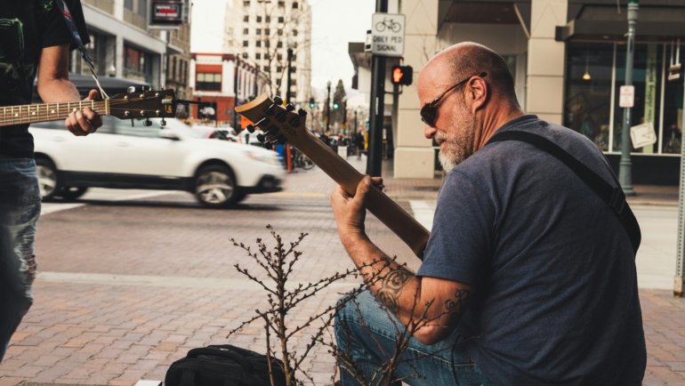 Traveling musician performing outdoors with guitar, embracing freedom and cultural exploration