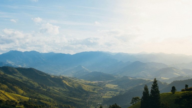 Travel nurse in scrubs standing in front of Alaskan mountains and wilderness, representing Alaska travel RN jobs combining nursing and adventure