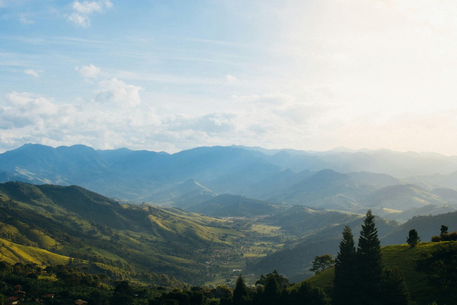 Travel nurse in scrubs standing in front of Alaskan mountains and wilderness, representing Alaska travel RN jobs combining nursing and adventure