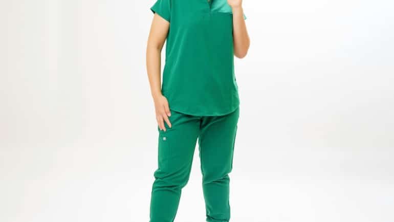 Travel nurse in scrubs standing outside a California hospital, representing travel nursing opportunities and lifestyle in California