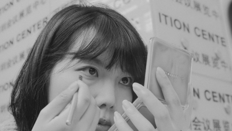 Portable travel magnification mirror with LED light used for detailed makeup application on the go