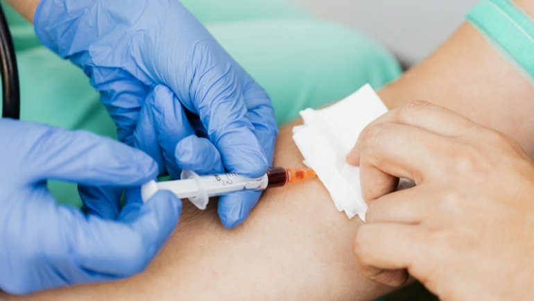 Professional traveling phlebotomist performing a mobile blood draw in a patient’s home, illustrating convenient and reliable mobile healthcare services