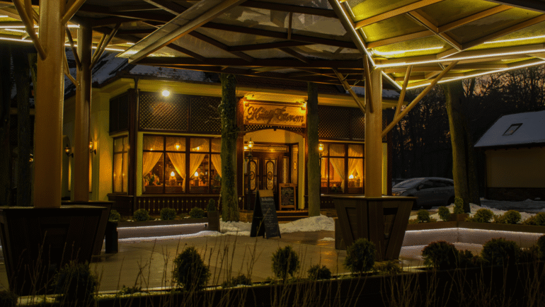 Cozy travelers inn exterior with warm lights at dusk, offering comfort and convenience for nearby travelers