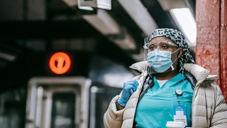 Certified nursing assistant standing in front of temporary housing during a 13 week travel healthcare contract
