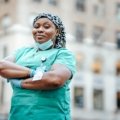 Certified Nursing Assistant smiling in a city during travel assignment, representing high-paying travel CNA jobs and adventure