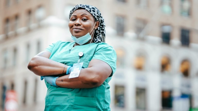 Certified Nursing Assistant smiling in a city during travel assignment, representing high-paying travel CNA jobs and adventure