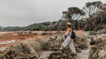 Confident solo traveler exploring scenic nature landscape representing empowerment and self-discovery