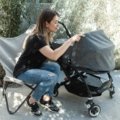 Parent pushing lightweight travel stroller with child at airport, showcasing compact and easy-to-use travel buggy for family trips