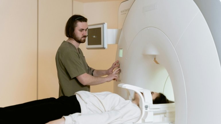 Traveling radiology technician operating medical imaging equipment in a hospital
