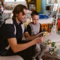 Children playing with colorful travel magnetic building tiles during a trip, showcasing portable educational toys for creative play