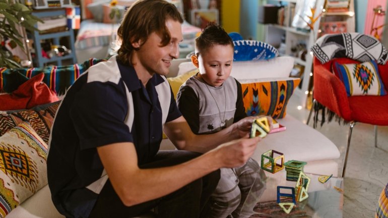Children playing with colorful travel magnetic building tiles during a trip, showcasing portable educational toys for creative play