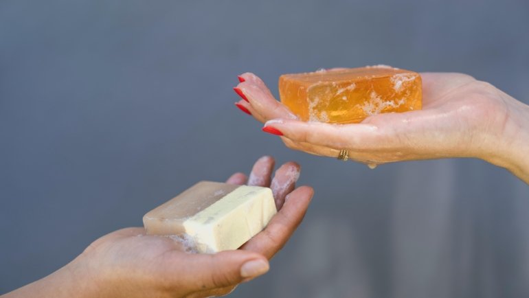 Portable travel hand soap bottle with travel accessories symbolizing hygiene and convenience during trips