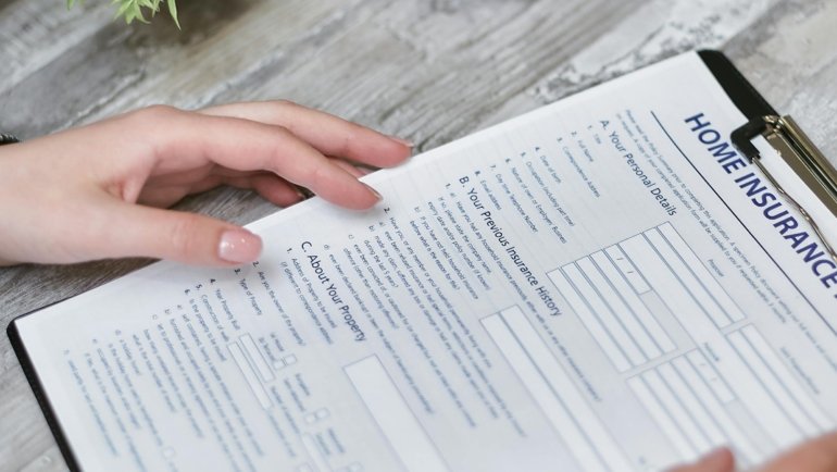 Person reviewing insurance policy documents highlighting the importance of insurance company verification and travelers NAIC number