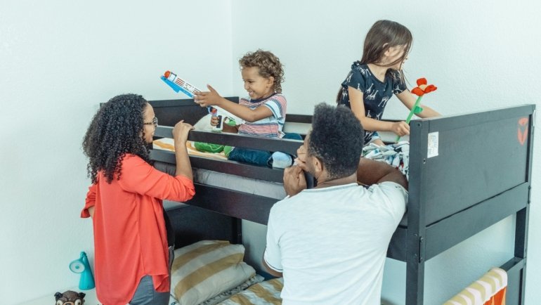 Interior of a family travel trailer with bunk beds showing children and parents enjoying a comfortable and practical road trip setup