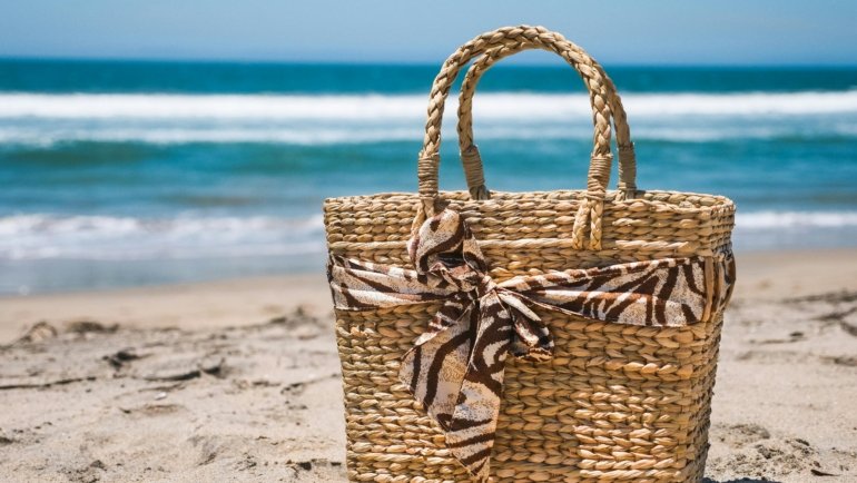 Stylish durable beach tote bag on sandy beach ready for travel essentials
