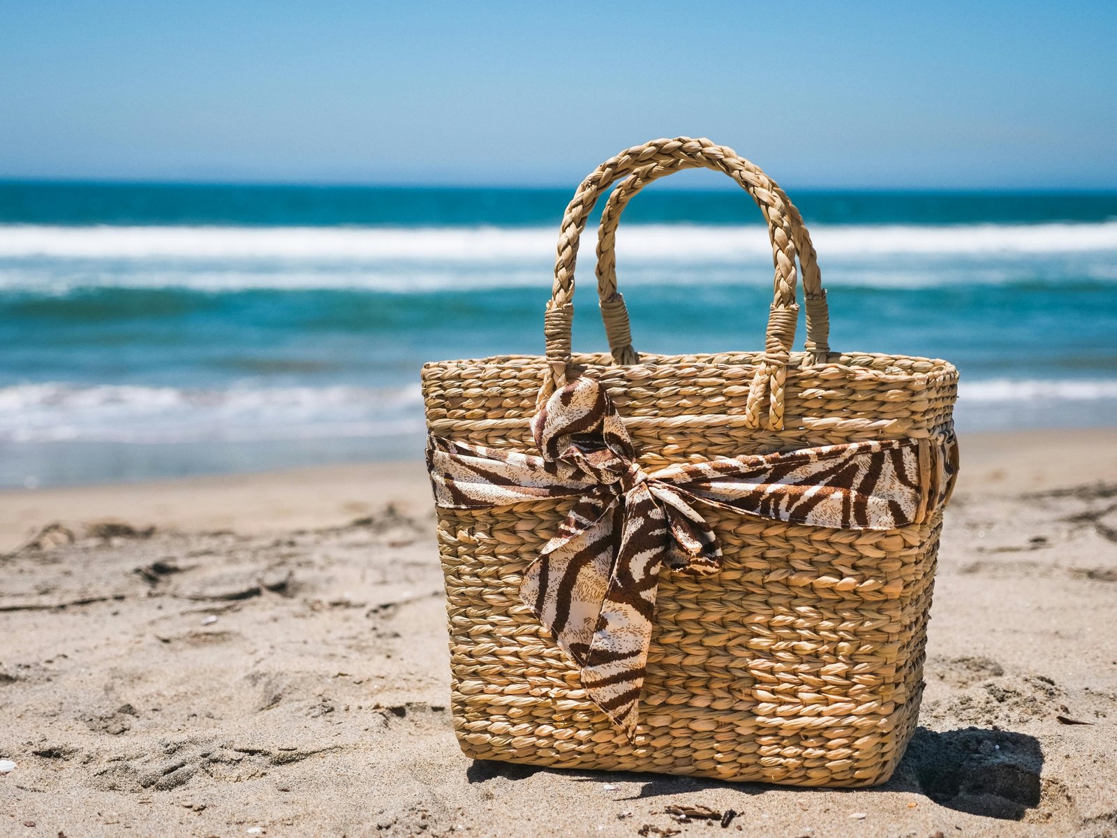 Stylish durable beach tote bag on sandy beach ready for travel essentials
