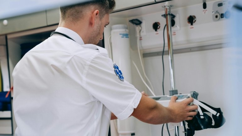 Travel cath lab tech assisting in cardiac catheterization procedure in hospital cath lab