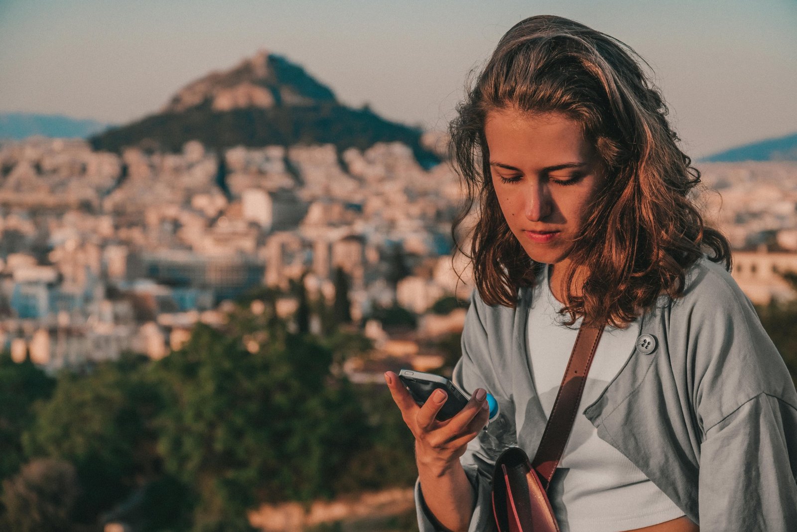 Traveler happily using a smartphone with travel apps to navigate and plan a stress-free trip