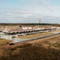 Busy highway rest stop with fuel stations, food outlets, and travelers resting during a road trip