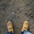 Durable travel boots worn by a traveler walking on a rugged outdoor trail, perfect for hiking and urban exploration