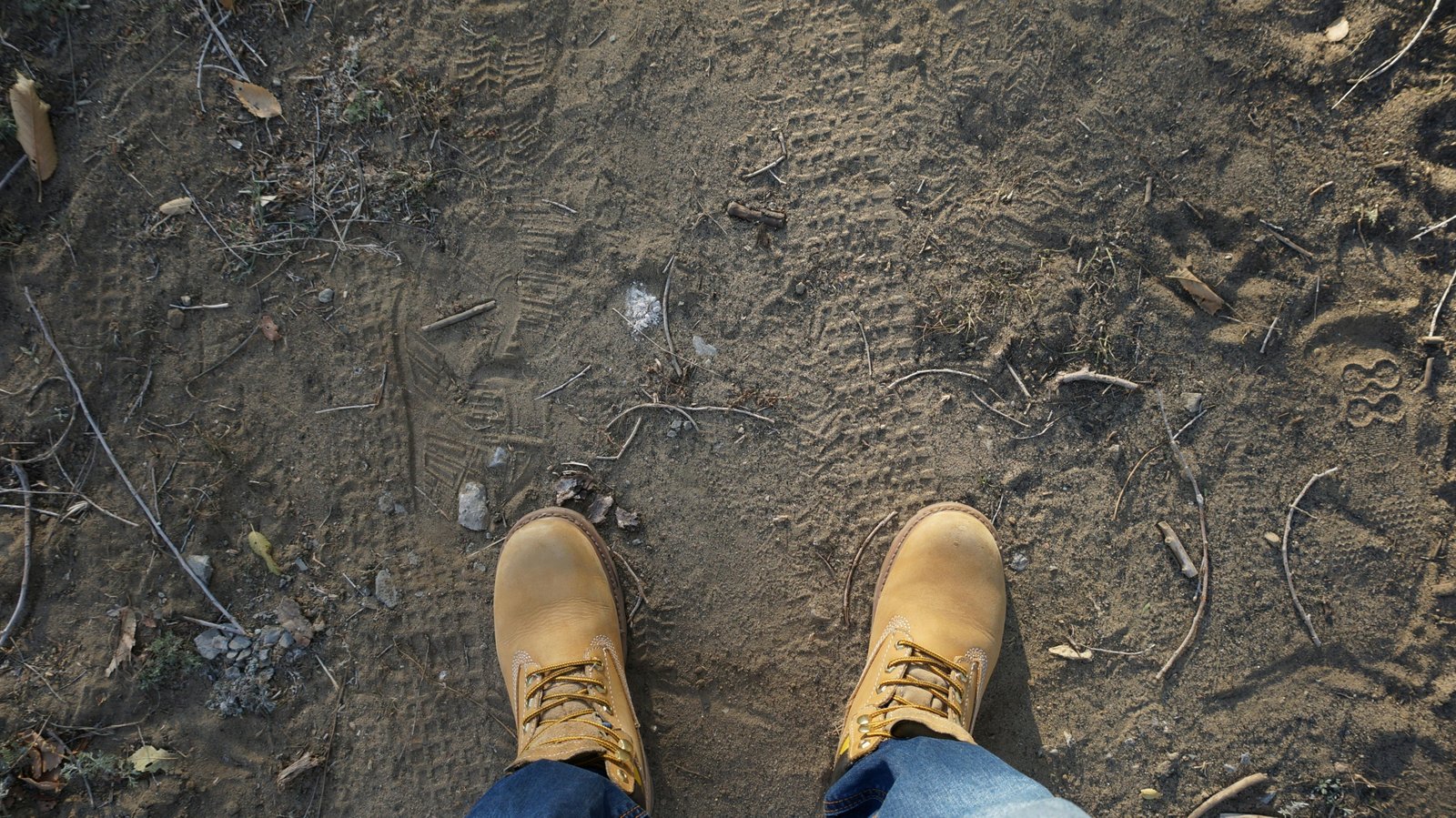 Durable travel boots worn by a traveler walking on a rugged outdoor trail, perfect for hiking and urban exploration