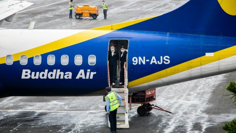 British Airways airline staff boarding plane using staff travel benefits, standing by at airport gate