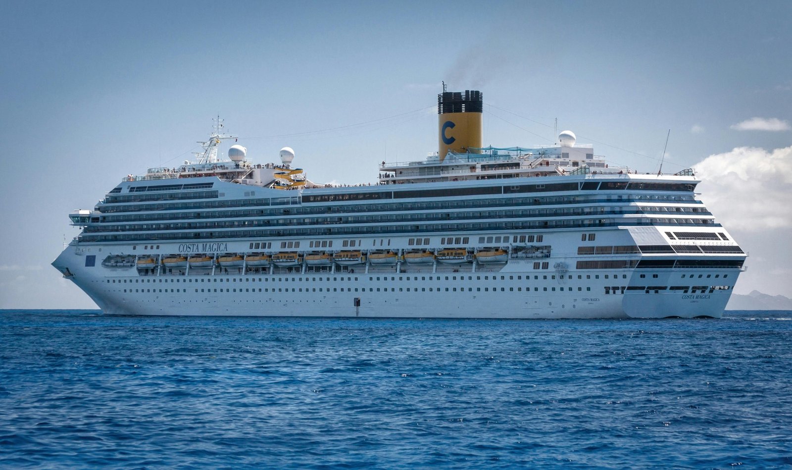 Modern cruise ship cruising smoothly through calm ocean waters under clear sky