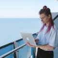 Digital nomad working remotely on laptop outdoors while traveling and enjoying financial freedom