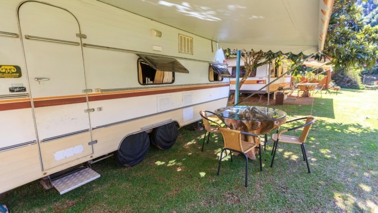 Travel trailer with electric awning extended creating a comfortable outdoor living space
