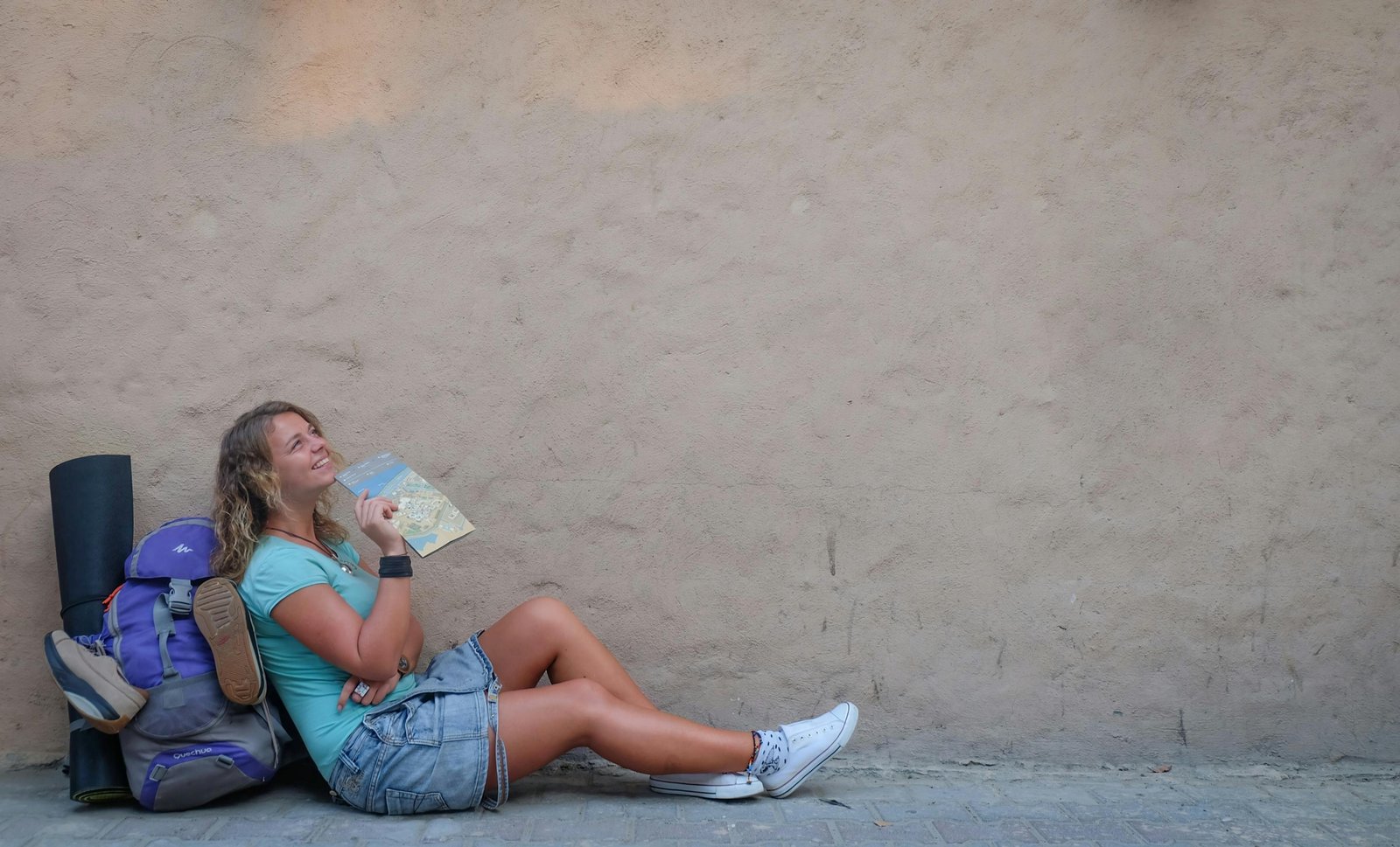 Traveler with backpack looking at a map outdoors, representing flexible and spontaneous luna travel style