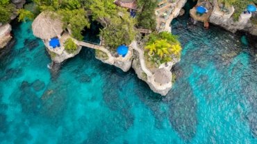 Luxury beachfront resort in Jamaica with private villas, clear turquoise ocean, and serene white sandy beach