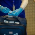 Traveler inspecting clothes and luggage for bed bugs to prevent infestations during travel