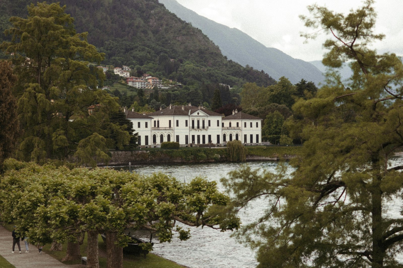 Beautiful springtime view of Lake Como with blooming gardens and calm blue waters under clear skies