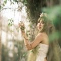 Fantasy female traveler using green dendro elemental magic in a lush magical forest