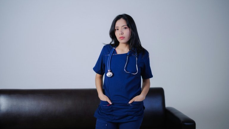 Licensed practical nurse ready for travel nursing assignment with suitcase and medical uniform