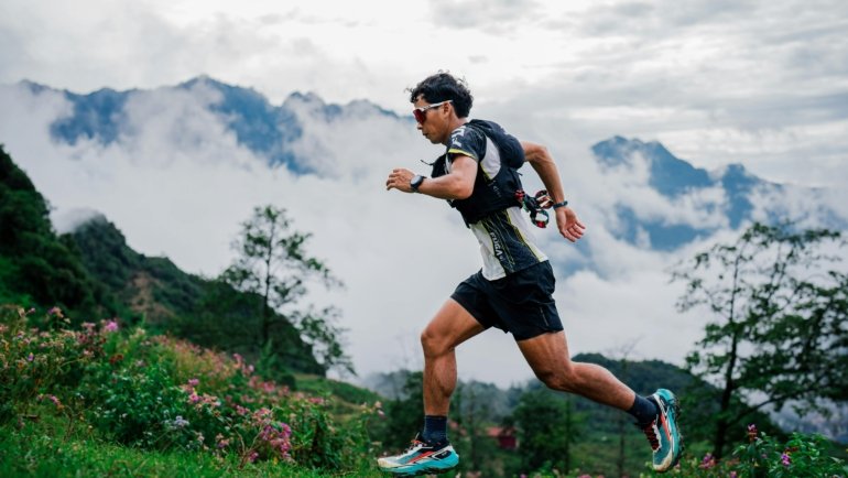 Ultramarathon runner on rocky mountain trail in forest during an endurance race