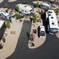 Comparison of fifth wheel and travel trailer RVs parked in nature showing different towing styles and spacious layouts for outdoor camping